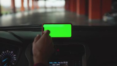 NEW YORK - 5 Nisan 2019: Genç eller araç akıllı telefon kullanıyor ve konsolda yeşil ekran ekranı var.