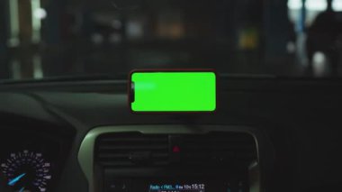 NEW YORK - 5 Nisan 2019: Hands man, konsolda yeşil ekran ekranlı akıllı telefon kullanıyor.