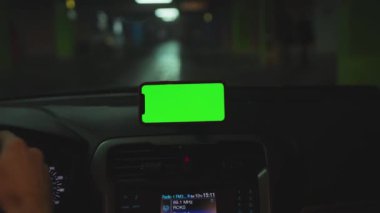 NEW YORK - 5 Nisan 2019: Hands man, konsolda yeşil ekran ekranlı akıllı telefon kullanıyor.