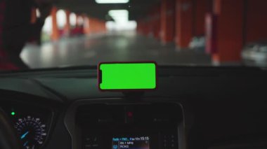 NEW YORK - 5 Nisan 2019: Hands man, konsolda yeşil ekran ekranlı akıllı telefon kullanıyor.