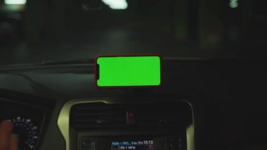 NEW YORK - 5 Nisan 2019: Hands man, konsolda yeşil ekran ekranlı akıllı telefon kullanıyor.