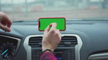 NEW YORK - 5 Nisan 2019: Hands man, konsolda yeşil ekran ekranlı akıllı telefon kullanıyor.