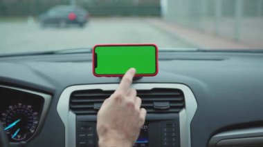 NEW YORK - 5 Nisan 2019: Hands man, konsolda yeşil ekran ekranlı akıllı telefon kullanıyor.