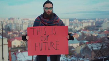 Ekoloji posterli genç adam portresi Bu bizim geleceğimiz panorama şehri çevre kirliliği dünya çöplüğü gönüllü maske çöpü geri dönüşüm çöpü yavaş çekim