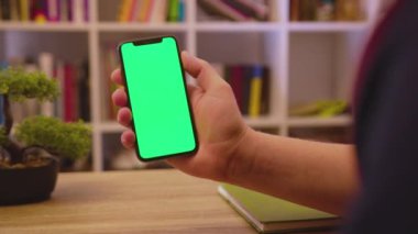 NEW YORK - 19 Mayıs 2019: Geri çekilen adam telefonu dikey yeşil ekran kullanımıyla tut dokunma dijital akıllı telefon ev iletişim teknolojisi internet krom sosyal medya arka planı
