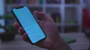 NEW YORK - 19 Mayıs 2019: Erkek elleri, harita taksisi ile bir telefon dokunuşu ekranı kullanıyor. Sohbet teknolojisi haberleşmesi, karanlık ışık bağlantısı, parmak hareketi, yavaş.