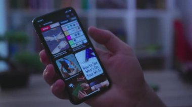 NEW YORK - 19 Mayıs 2019: Genç adam telefon dokunuşu ekranı ile ilham verici görüntüler kullanarak sohbet teknolojisi iletişimi, karanlık ışık bağlantısı, parmak hareketi gibi cihazlar kullanıyor