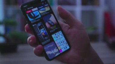 NEW YORK - 19 Mayıs 2019: Genç adam telefon dokunuşu ekranı ile ilham verici görüntüler kullanarak sohbet teknolojisi iletişimi, karanlık ışık bağlantısı, parmak hareketi gibi cihazlar kullanıyor
