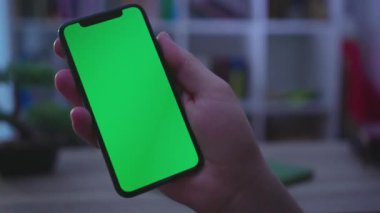 NEW YORK - 19 Mayıs 2019: Ağır çekimli adam telefonu dikey yeşil ekran kullanımıyla tut, dokunmatik dijital akıllı telefon ile akşam haberleşme teknolojisi iş dünyası internet krom sosyal medya