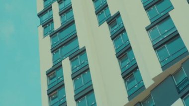 Temiz mavi gökdelene karşı alçak açılı güzel bir gökdelen. Modern konut inşaatı. Gayrimenkul. Reklamcılık. Şehir manzarası.