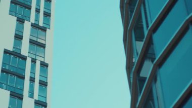 Şehir merkezindeki modern cam gökdelen binalarının manzarası mavi gökyüzüne yükseliyor. Şehir manzarası. Ofis binaları.