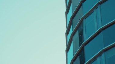 Blye cam şeffaf gökdelen perspektif açısından. Mavi berrak gökyüzüne karşı modern yüksek ofis binasına yakın çekim.