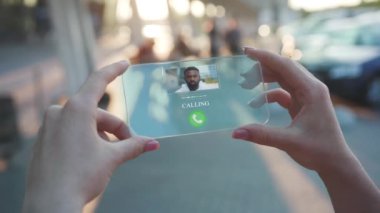 Şeffaf telefonundan gelen arama. Geleceğin Akıllı Telefonu. Kadın, Fütürist Tasarımlı Akıllı Telefon Kullanıyor. Dijital Gelecek kavramı. Holografik Teknoloji. Dijital Teknoloji. İş Arkaplanı.