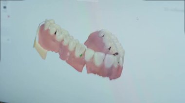 NEW YORK - 19 Şubat 2020: Bilgisayar ekranında dönen yeni sahte diş modelinin animasyon çekimi. Profesyonel diş teknisyeni, gelecekteki üretimler için yeni diş implantı şablonu oluşturuyor. Sağlık Hizmetleri