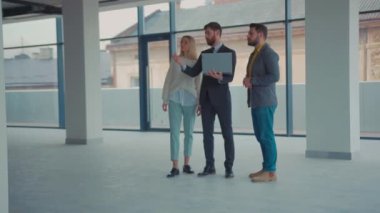 Emlakçı, çift için yeni boş bir bina gösteriyor. Etrafına bak. Laptop emlakçısı, Kafkasyalı, kiracı, ev kiracısı, müşteri hizmetleri, ağır çekimde.