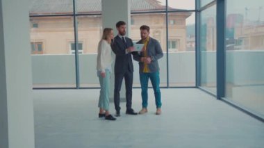 Boş bir binada birkaç yeni daire gösteren bir emlakçı var. Laptop işi, beyaz emlakçılık, kira danışmanlığı, ev mülkü müşterisi yavaş çekimde ev satın alıyor.