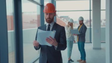 Portre emlakçısı miğfer takıyor. Kameraya bakın. Yeni apartman boş. Emlakçılık işi.