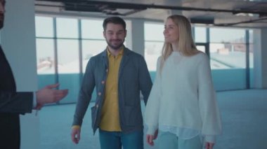 Genç bir emlakçı, birkaç boş daire gösteriyor. Etrafına bak. Dizüstü bilgisayar, emlakçılık, emlak, kariyer, komisyonculuk, hizmet, ağır çekimde ikamet.