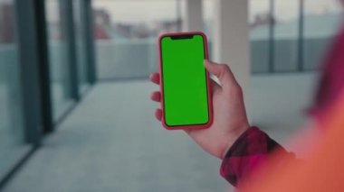 NEW YORK - 5 Mart 2020: Akıllı telefon yeşil ekranı kullanan genç erkek işçiler inşaat mühendisi, telefon endüstrisi, cep telefonu, cep telefonu, iletişim cihazları