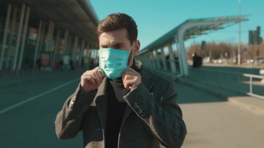 Koruyucu Yüz Maskesi takan yüz adamı COVID-19 Coronavirus enfeksiyonuna bak. Havaalanı salgını virüsü. Erkek turist salgını.