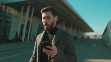 Hasta genç adam telefon hapşırığı kullanıyor. Elinde COVID-19 Coronavirus enfeksiyonu var. Havaalanı salgını salgını.