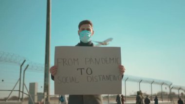 Sokakta koruyucu maske takan genç bir turistin portresi salgından sosyal mesafeye kadar havaalanı konsepti sağlık ve güvenlik kavramı COVID-19 Coronavirus enfeksiyonu yavaş çekim