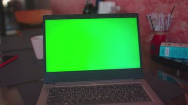 Ev dizüstü bilgisayarında yeşil ekranlı boş iletişim defteri internet tablosu teknolojisi monitörü klavye kahvesi yavaş çekim çevrimiçi.