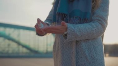 Ellerini kapat kadın antiseptik dezenfekte spreyi serpiyor ve bakteriler COVID-19 koronavirüs enfeksiyonunu havaalanı pandemik salgın hastalık salgını yakınında yavaş çekimde önlüyor.