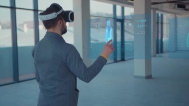 Artırılmış Gerçeklik. Erkek Doktor Bakışları: Tıbbi Grafikler, 3D Hologram DNA hologramı, Pulmoner Sistem, Kas Sistemi, COVID-19 VR gözlük ve kulaklık takan. Geleceğin tıbbı. VR Gözlükleri
