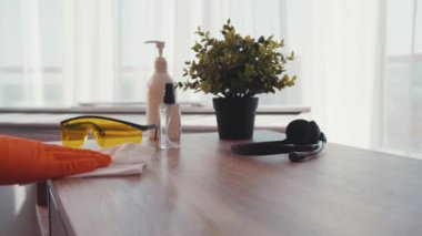 Ağır çekimde adam daireyi sterilize ediyor. Antiseptik spreyle bir masa yüzeyini temizliyor. Evdeki enfeksiyondan evi temizliyor.