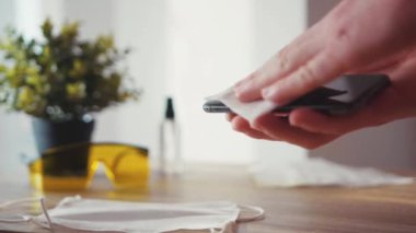 İnsan elleri antiseptik ve dezenfekte edici cep telefonu ekranı kullanıyor. Hijyen virüsü antibakteriyel koronavirüs salgını bakterisi. Enfeksiyonu yavaş çekimde temizliyor.