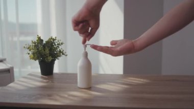 Adam prezervatifi kapat ve ellerini yıkamak için sıvı antiseptik ver. Evde kal Coronavirus COVID19 salgını. Masa enfeksiyonunu dezenfekte et.