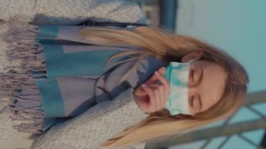 COVID-19 Coronavirus enfeksiyonundan korunmak için koruyucu yüz maskesi takan dikey ekran kadını havaalanı salgını salgını virüsü turistik hava hastalıkları yavaş çekim hastalığı