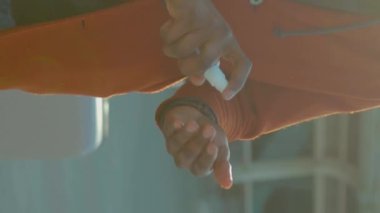 Dikey ekran video Afro-Amerikan erkek temizlik için dezenfekte spreyi serpiyor ve havaalanı pandemik salgın hastalığının yakınında COVID-19 koronavirüs enfeksiyonunu önlüyor.