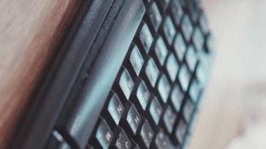 Dikey ekran eller dizüstü bilgisayarın klavyesini antiseptik sprey ve eldivenlerdeki ıslak mendille dezenfekte ediyor virüs antibakteriyel pandemik video hijyenik ev enfeksiyonunda kalıp koronavirüsü temizliyor.