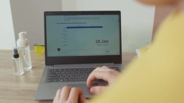 NEW YORK - 28 Mart 2020: Dizüstü bilgisayarda Coronavirus 'un önlenmesi hakkında önemli bir makale okuyan genç bir yetişkin. Bilgi salgını. İnsanlar evden çalışır..