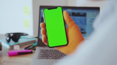 NEW YORK - 28 Mart 2020: akıllı telefon dikey ekranında haber koronavirüsü okuyan omuz bilimci üzerinde. İnsanlar ve teknoloji. Evde kal. İş konsepti.