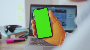 NEW YORK - 28 Mart 2020: Yakın plan genç doktor, evde çalışan yeşil ekran dikey modellemesi üzerinde Coronavirus 'un haberlerini okuyor. Karantina sırasındaki insanlar.