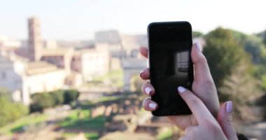 ROME, ITALY - 19 Mayıs 2017: Kapatın elinizi genç bayan dikey yeşil ekran arka planlı telefonu kullanın antik şehir sokak iletişimi güneşli internet bulanık akıllı telefon mesajı oluşturun
