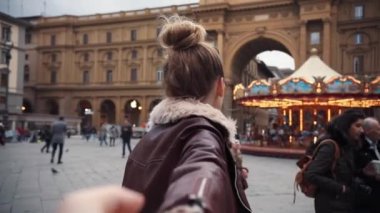 FLORENCE, İTALYA - 21 Mayıs 2017: Beni takip edin, çekici genç bir kadın Avrupa şehrinin kız arkadaşı turistik elde mutlu bir gülümseme ile bir erkeğe yol gösteriyor.