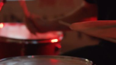 Davul çalan bir adamın elleri, kırmızı hafif davul, davulcu baget eğlence enstrümanı müzikal, rock, sound stage cymbal metal müzik grubu, Dark Light 'ı yener.