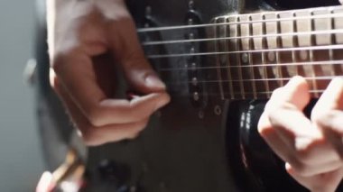 Gitar çalan bir adamın ellerinin yakın çekimi blues konser sanatçısı rock şarkısı, eğlence parmakları arka plan müzik silueti sanatsal güneş ışığı yavaş çekim