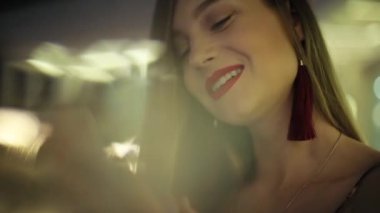 Kırmızı dudaklı genç bir kadın telefon gecesinde gülümsüyor mutlu bir kız ol internet yüz teknolojisi açık hava mobil şehir akıllı telefon caddesi online cep telefonu gündelik telefonu.