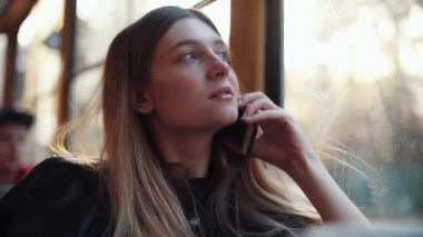 Trendeki çekici kızın portresi akıllı telefondan gülümseyen mutlu bir kadın hisset internet teknolojisi cep telefonu akıllı telefon tramvay kadın nakliye aracı yavaş çekim