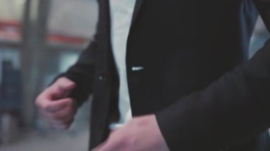 Ceketinin düğmelerini bağlayan takım elbiseli bir adam. Dışarı çıkmaya hazırlanıyor. İş adamı parası.