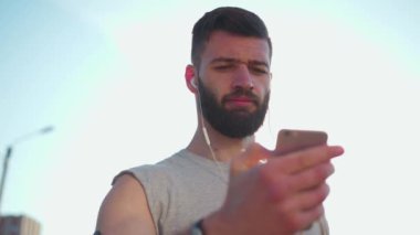 Portre genç sporcusu. Spor kıyafetleri içinde gülümseyen ve dışarıda koşan biri. Gün batımını dinle.