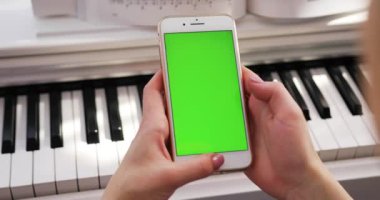 Tokio, Japonya - 7 Nisan 2018. Akıllı telefon kullanan, dikey yeşil ekran arka plan piyano kromakey beyaz dijital cihaz zengin avuçlarını modern yaşam tarzına uygun hale getiriyor.