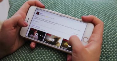 Tokio, Japonya - 7 Nisan 2018. Oturma odasındaki logo tasarımı internet teknolojisi uygulaması dokunmatik ekranda dinlenirken kadın ellerini yatay akıllı telefon kullanarak kapat.