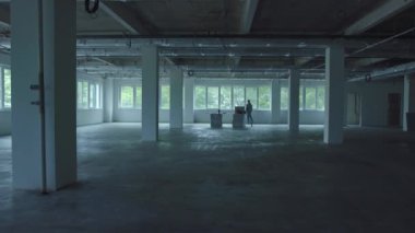 Beyaz koridor duvarlarını kapatın. Kadın bina içi terk edilmiş eski perili harabeler. Teknoloji yapımı terk edilmiş fabrika sütunları terk edilmiş.