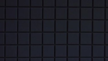 Duvarın yüzeyi geometrik karelerle kaplıydı. Hareketli yakın plan görüntüsü. Sahte arka plan efekti, moda tasarımı, çerçeve yapısı, sanat, karanlık hareket mimarisi makro.